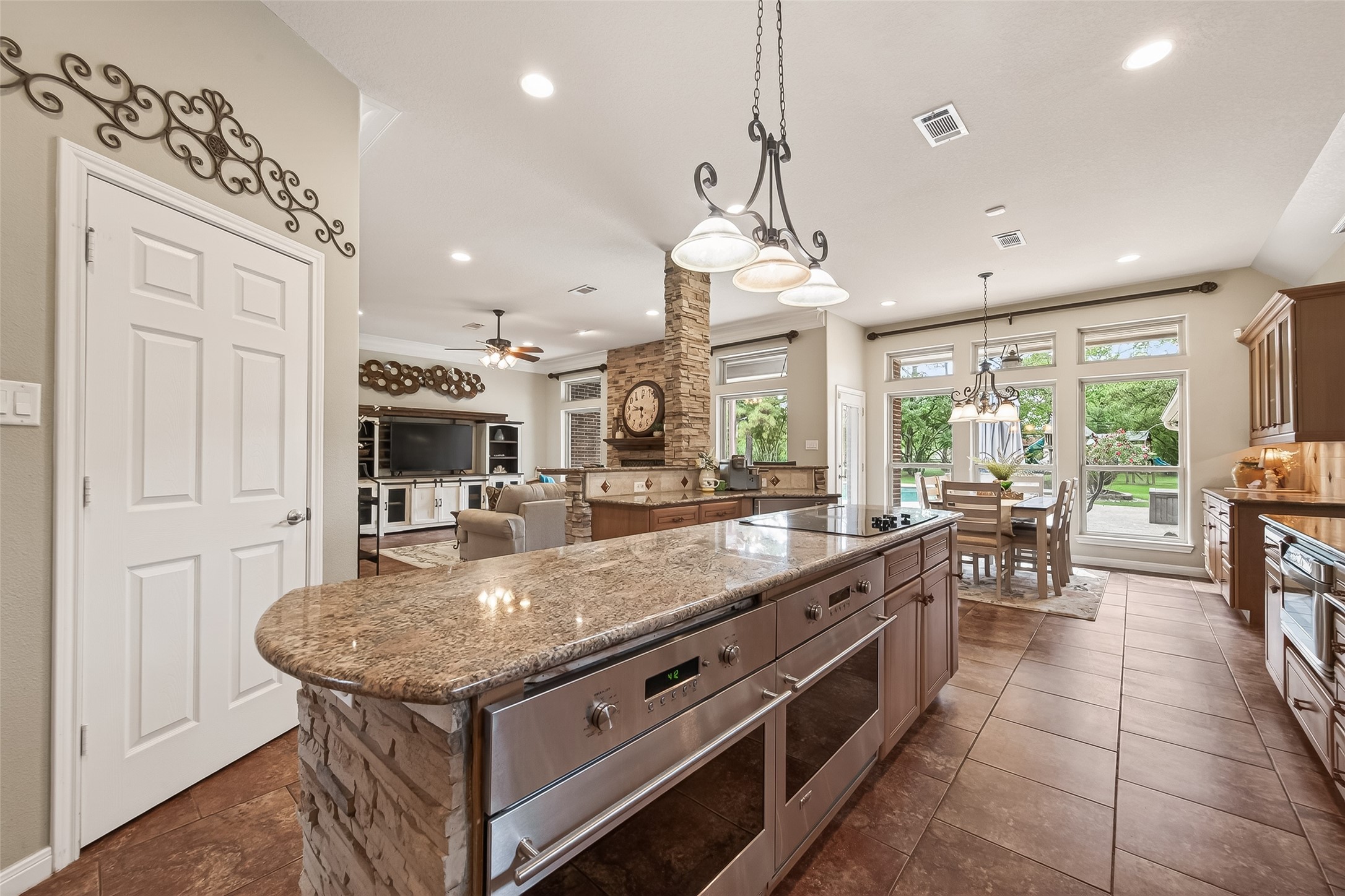 17603 Bending Cypress Road Cypress, TX 77429 - Photo 13 of 43 The kitchen features a large island with granite countertops, stainless steel appliances, and elegant lighting fixtures.