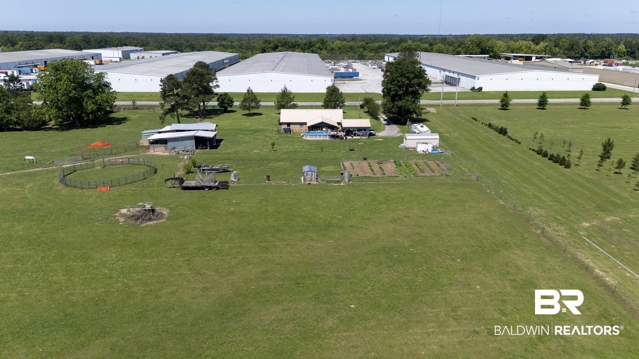 30580 County Road 49 Loxley, AL 36551 - Photo 17 of 32 Expansive green acreage featuring a residential structure, multiple outbuildings, and a fenced garden area