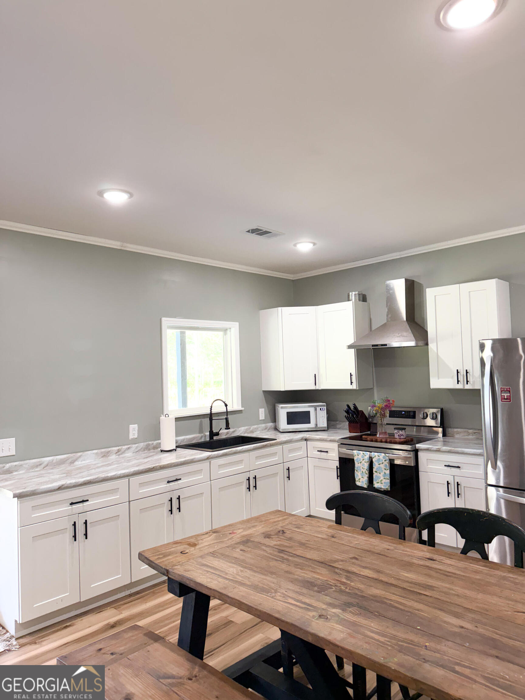 210 St Galilee Road Swainsboro, GA 30401 - Photo 3 of 18 a kitchen with stainless steel appliances granite countertop a stove top oven a sink dishwasher and cabinets with wooden floor