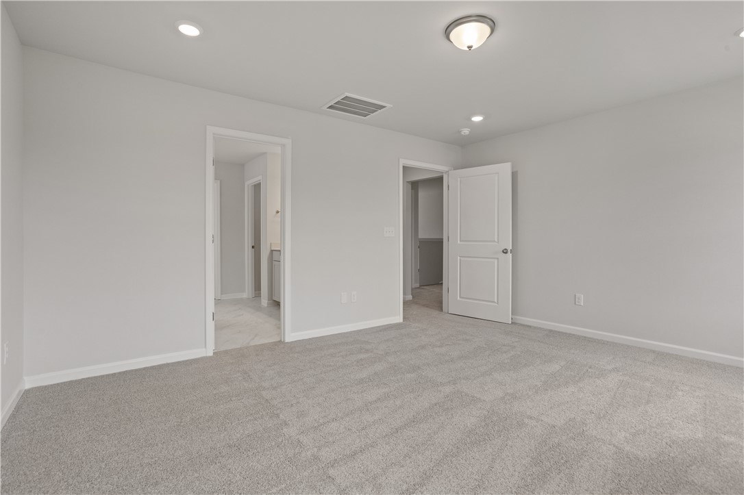 555 Hydrangea Street, Unit LOT 47 Seneca, SC 29678 - Photo 23 of 38 A well-lit bedroom features plush carpeting and convenient access to a private bathroom and closet.