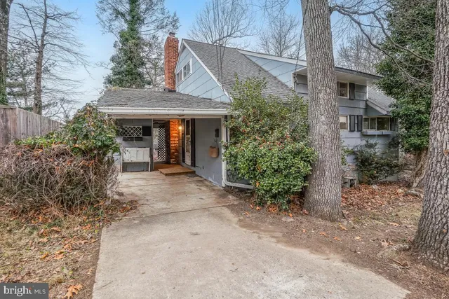 a view of a house with potted plants and a yard