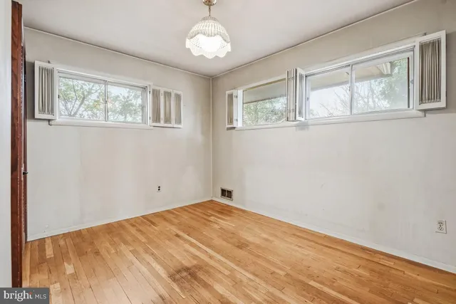 a view of empty room with wooden floor