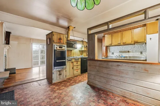 a view of kitchen with stainless steel appliances cabinets and a large window