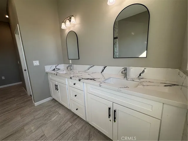 a en suite bathroom with a double vanity sink and a mirror
