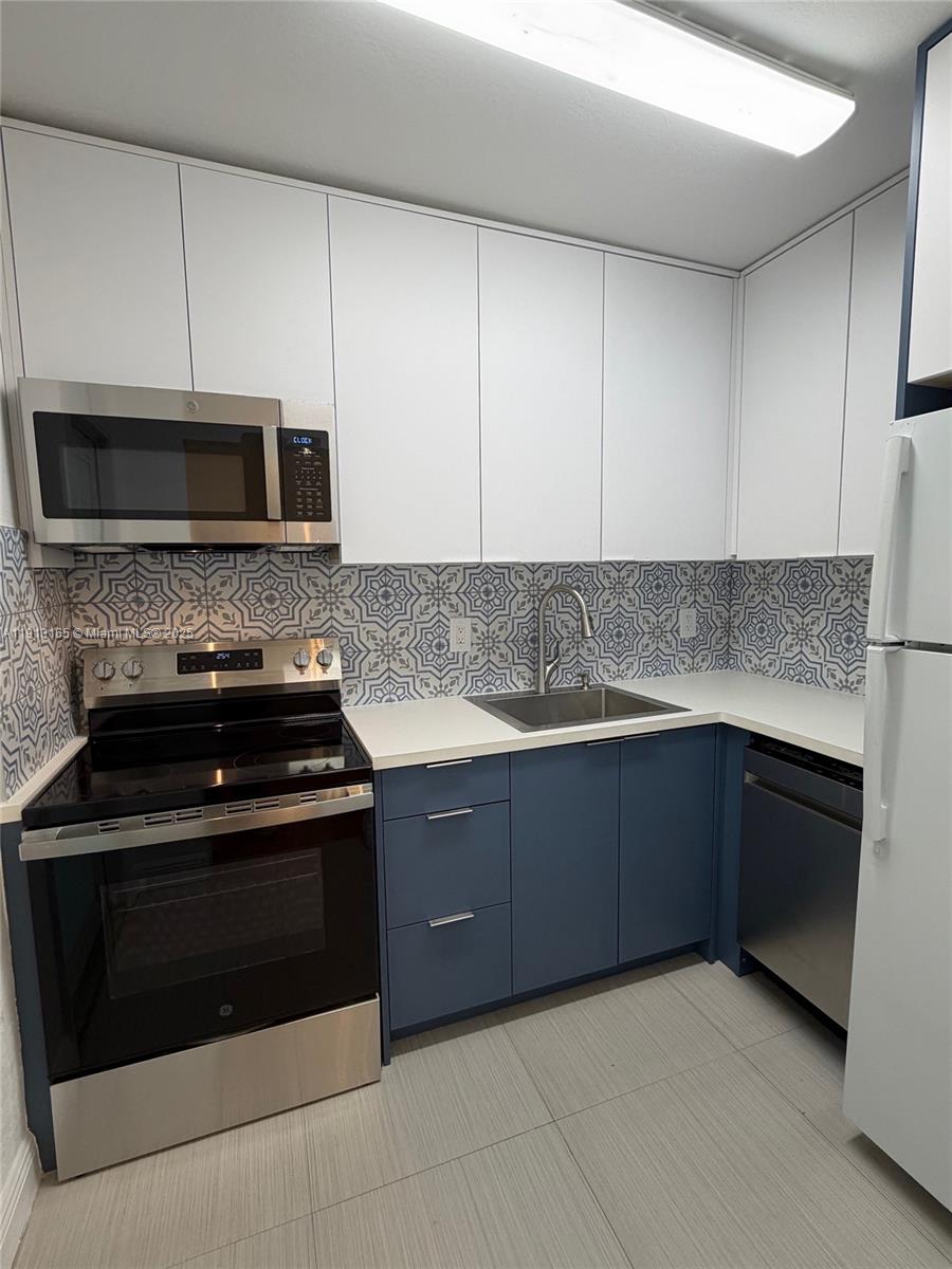 6855 Northeast 5th Avenue, Unit C Miami, FL 33138 - Photo 4 of 13 a kitchen with granite countertop white cabinets and stainless steel appliances