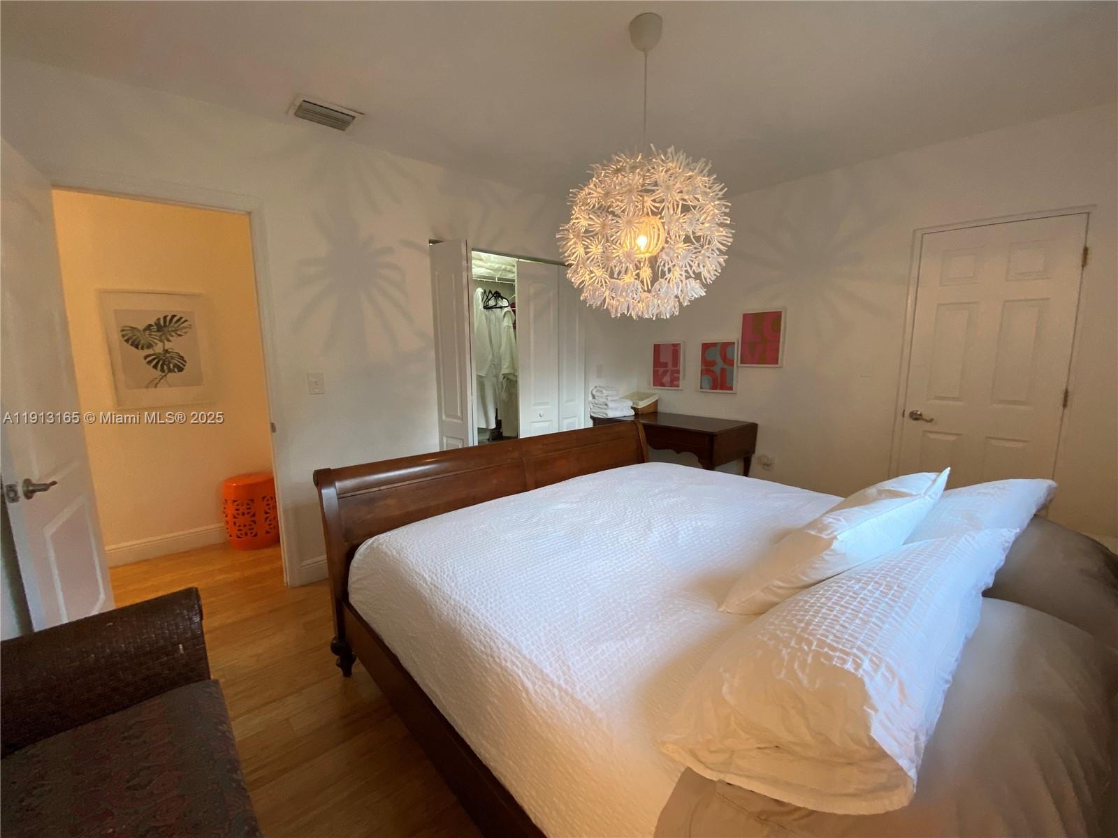 6855 Northeast 5th Avenue, Unit C Miami, FL 33138 - Photo 8 of 13 a bedroom with a bed and a chandelier