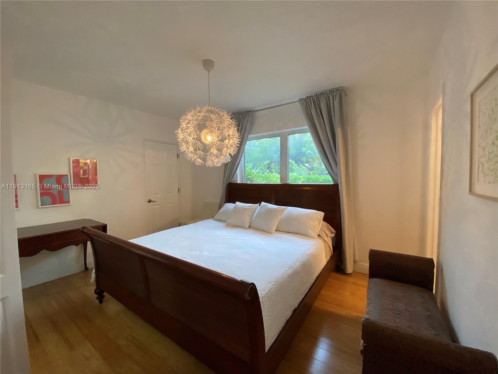 6855 Northeast 5th Avenue, Unit C Miami, FL 33138 - Photo 9 of 13 a bed sitting in a bedroom next to a window