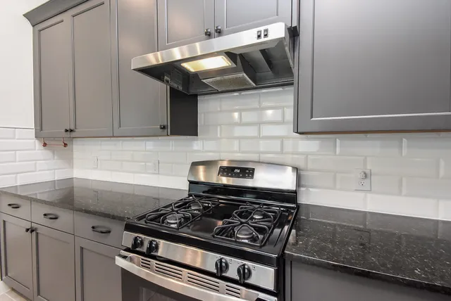 a kitchen with granite countertop a sink and chandelier