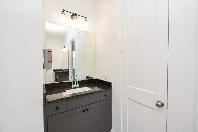 a spacious bathroom with a granite countertop sink a toilet and shower