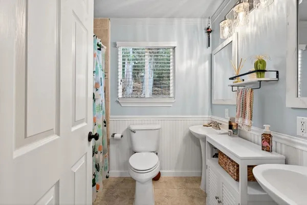 a bathroom with a sink a toilet and a mirror