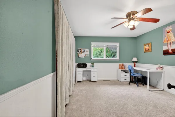 a view of a workspace with furniture and a window