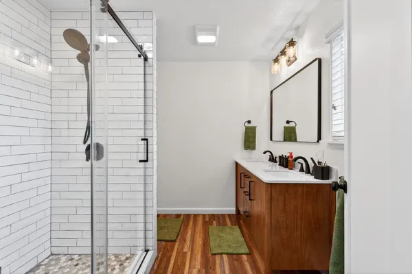 a bathroom with a sink a mirror and shower