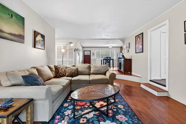 a living room with furniture a rug and a flat screen tv