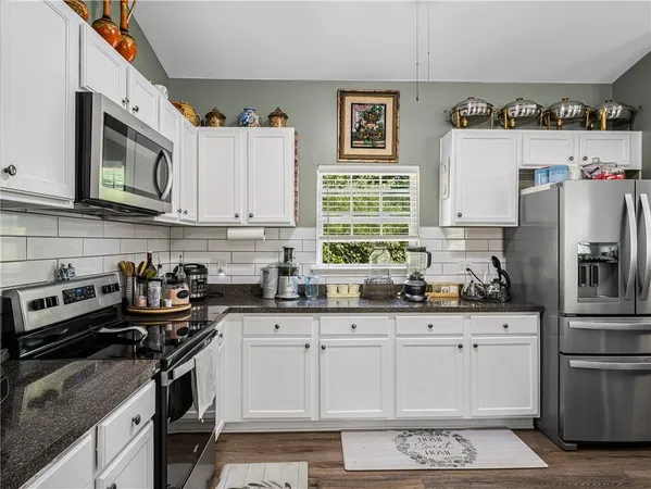 a kitchen with stainless steel appliances granite countertop a stove a sink dishwasher and a refrigerator