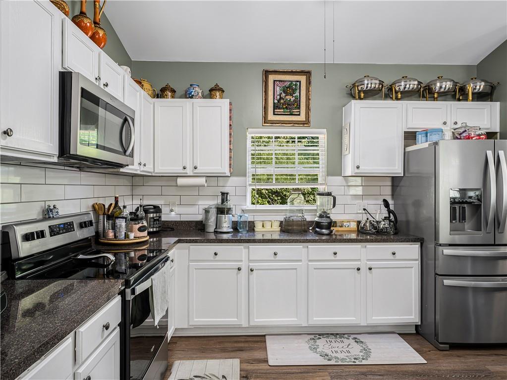 42 Highlander Trail Southwest Rome, GA 30165 - Photo 4 of 15 a kitchen with stainless steel appliances granite countertop a stove a sink dishwasher and a refrigerator