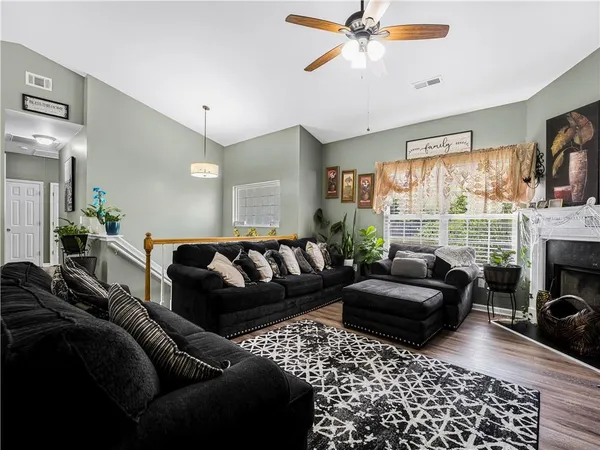 a living room with furniture a fireplace and a large window