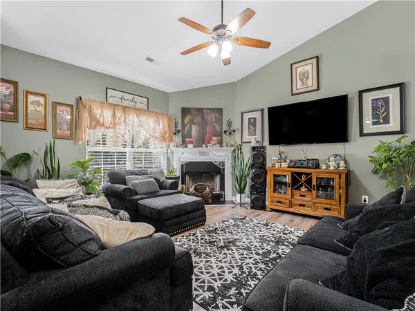 a living room with furniture a flat screen tv and a fireplace