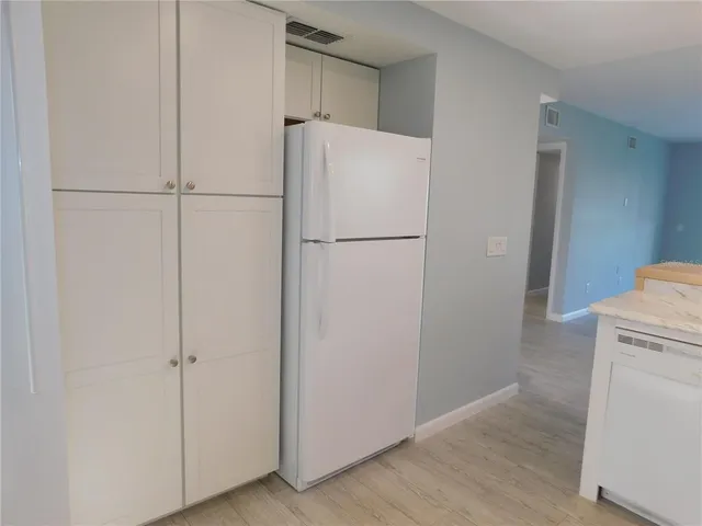 a white refrigerator freezer and a dishwasher sitting in a kitchen
