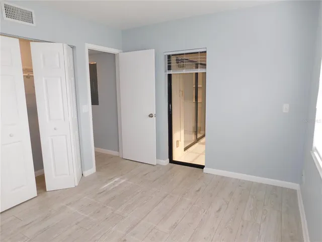 an empty room with wooden floor and a window