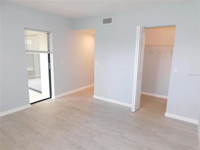 an empty room with windows and closet