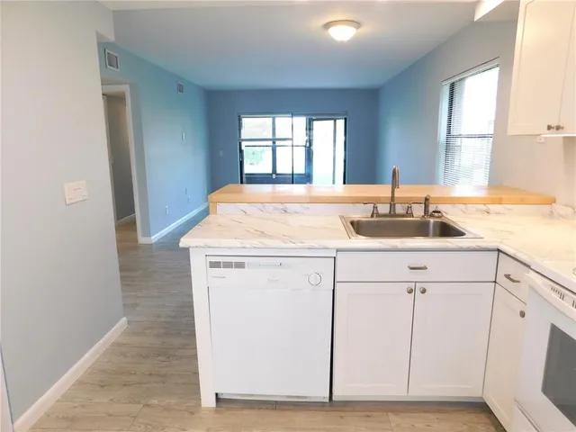 a kitchen with granite countertop white cabinets and white appliances
