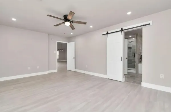 wooden floor in an empty room with a ceiling fan