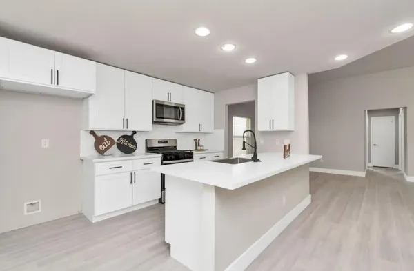 a kitchen with appliances a sink and cabinets