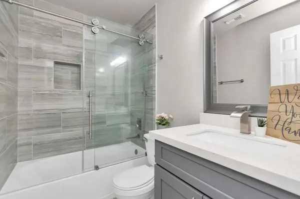 a bathroom with a sink a toilet and shower