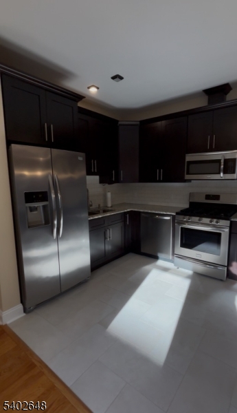 a kitchen with stainless steel appliances granite countertop a sink and a refrigerator