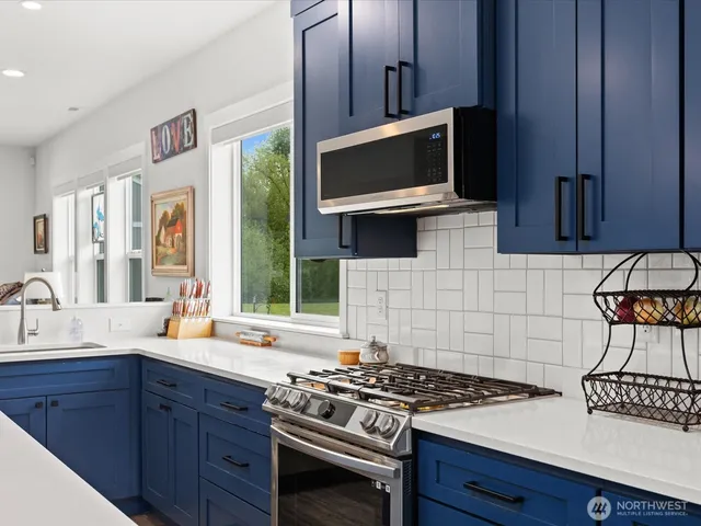 a kitchen with stainless steel appliances a stove microwave and sink