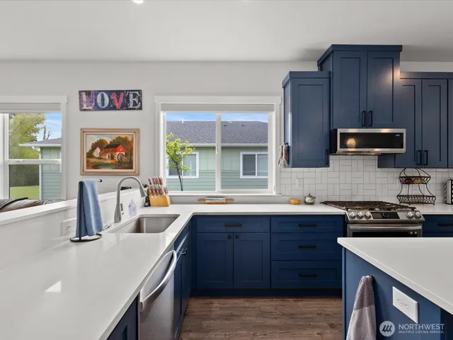 a kitchen with stainless steel appliances granite countertop a sink and a stove