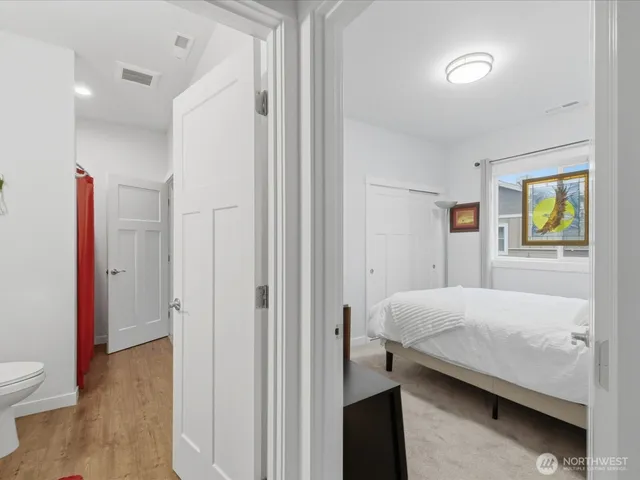 a spacious bedroom with a bed and wooden floor