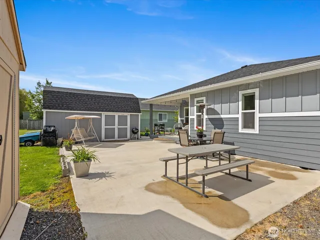 a view of a chair and table in the back yard of the house