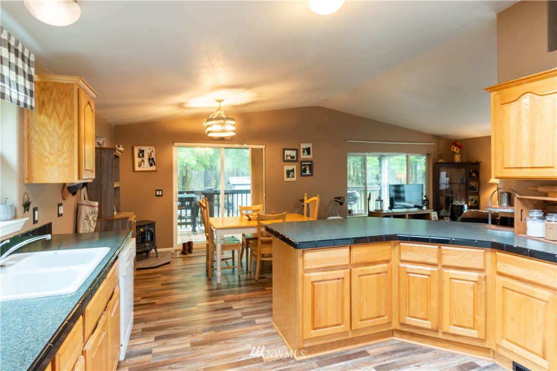 176 Nelson Road Winlock, WA 98596 - Photo 5 of 16 a view of a kitchen with kitchen island granite countertop a large window cabinets and a sink