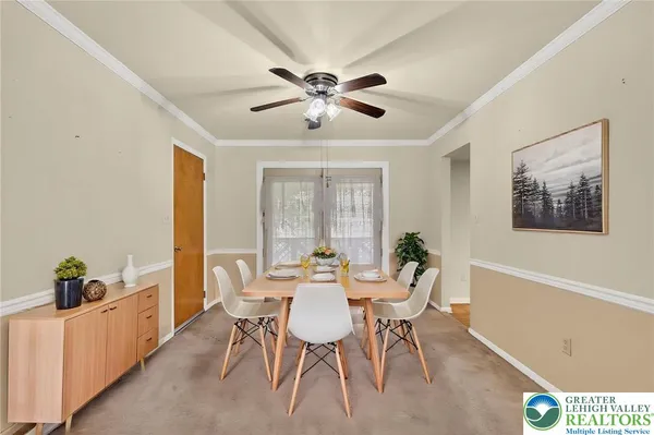 a kitchen with stainless steel appliances a sink a stove a refrigerator cabinets and a dining table