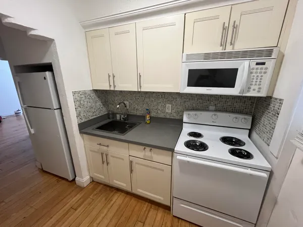 a kitchen with a refrigerator sink and cabinets