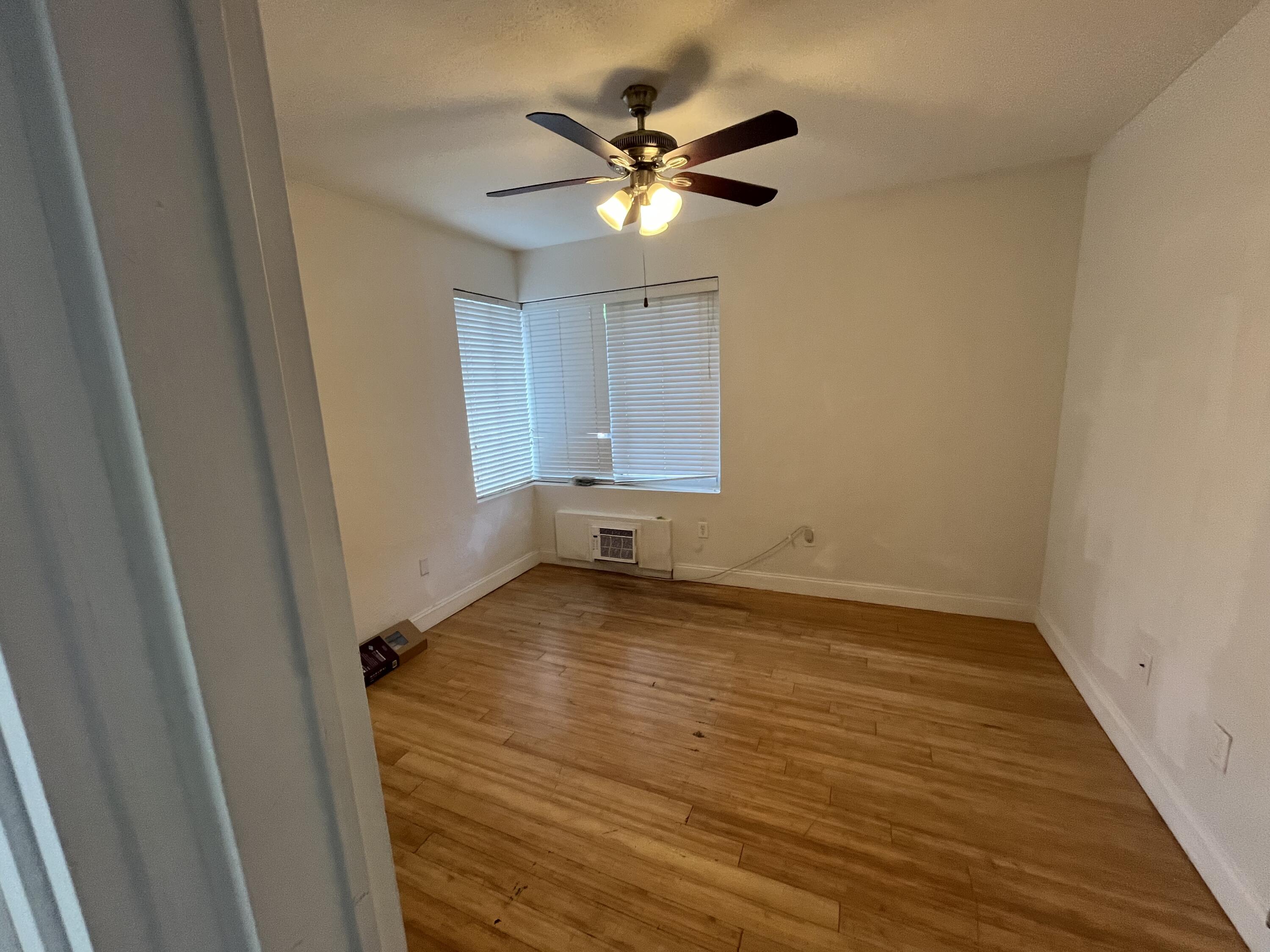 320 80th Street, Unit 4 Miami Beach, FL 33141 - Photo 3 of 11 wooden floor in an empty room with a window