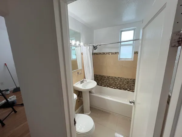 a bathroom with a sink a toilet a mirror and shower