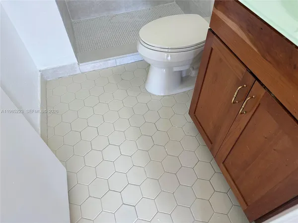 an empty room with wooden floor and a bathroom