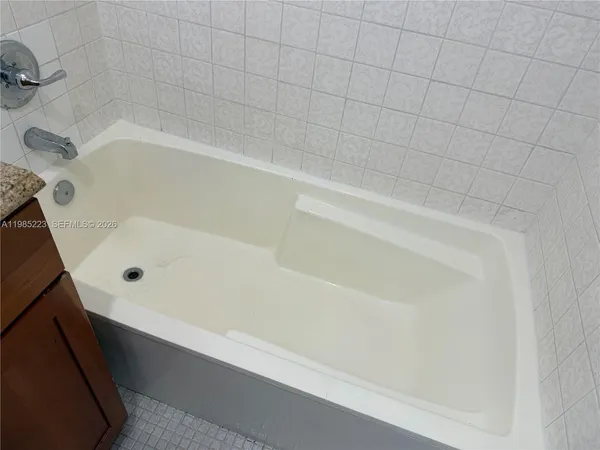 a bathroom with a granite countertop bathtub