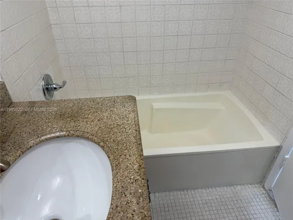 a bathroom with a granite countertop toilet and sink