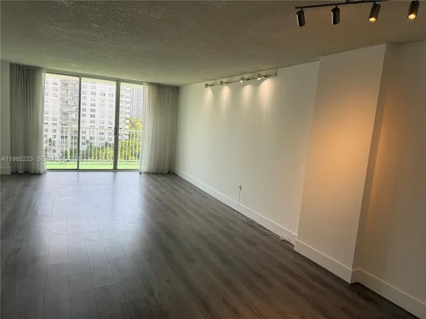 an empty room with wooden floor and a window