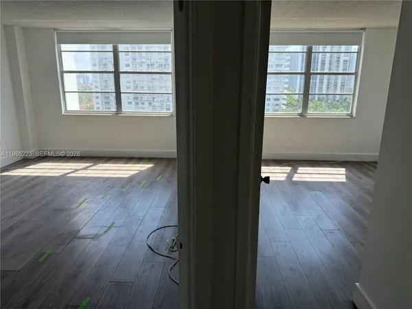 a view of an empty room with wooden floor