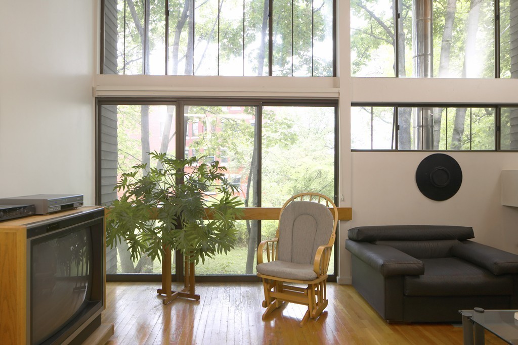 30 Inman Street, Unit C Cambridge, MA 02139 - Photo 3 of 8 a living room filled with furniture and a floor to ceiling window