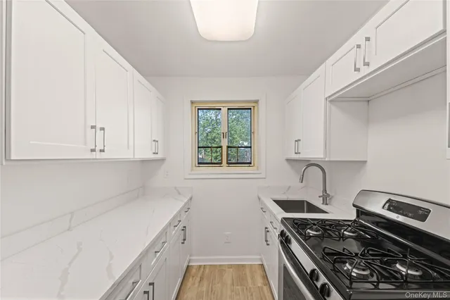 a kitchen with a stove and a white cabinets