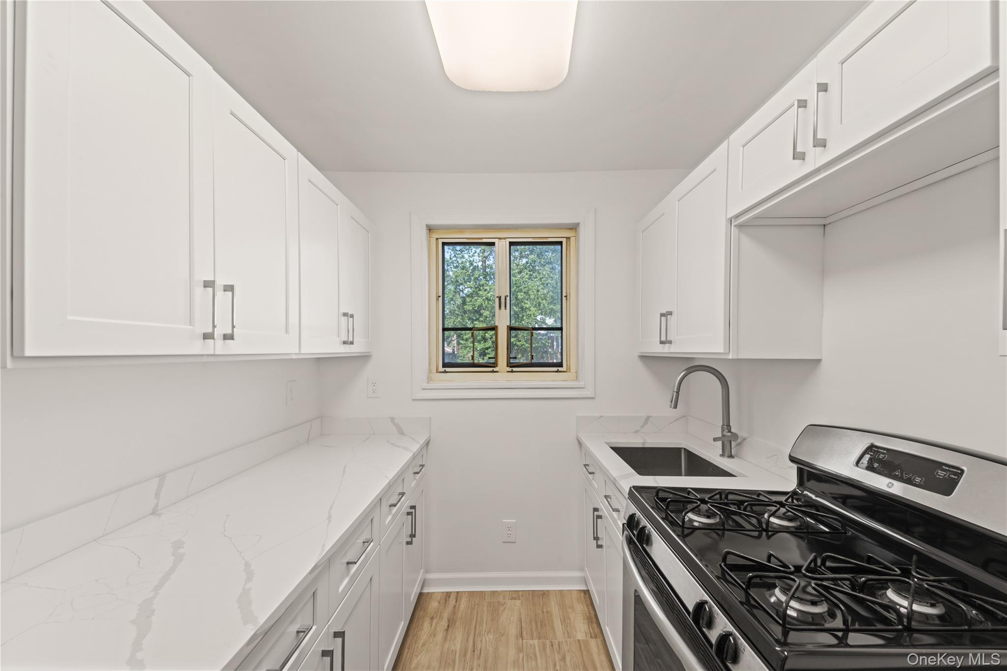 224-17 Manor Road, Unit LOWR Queens, NY 11427 - Photo 11 of 16 a kitchen with a stove and a white cabinets