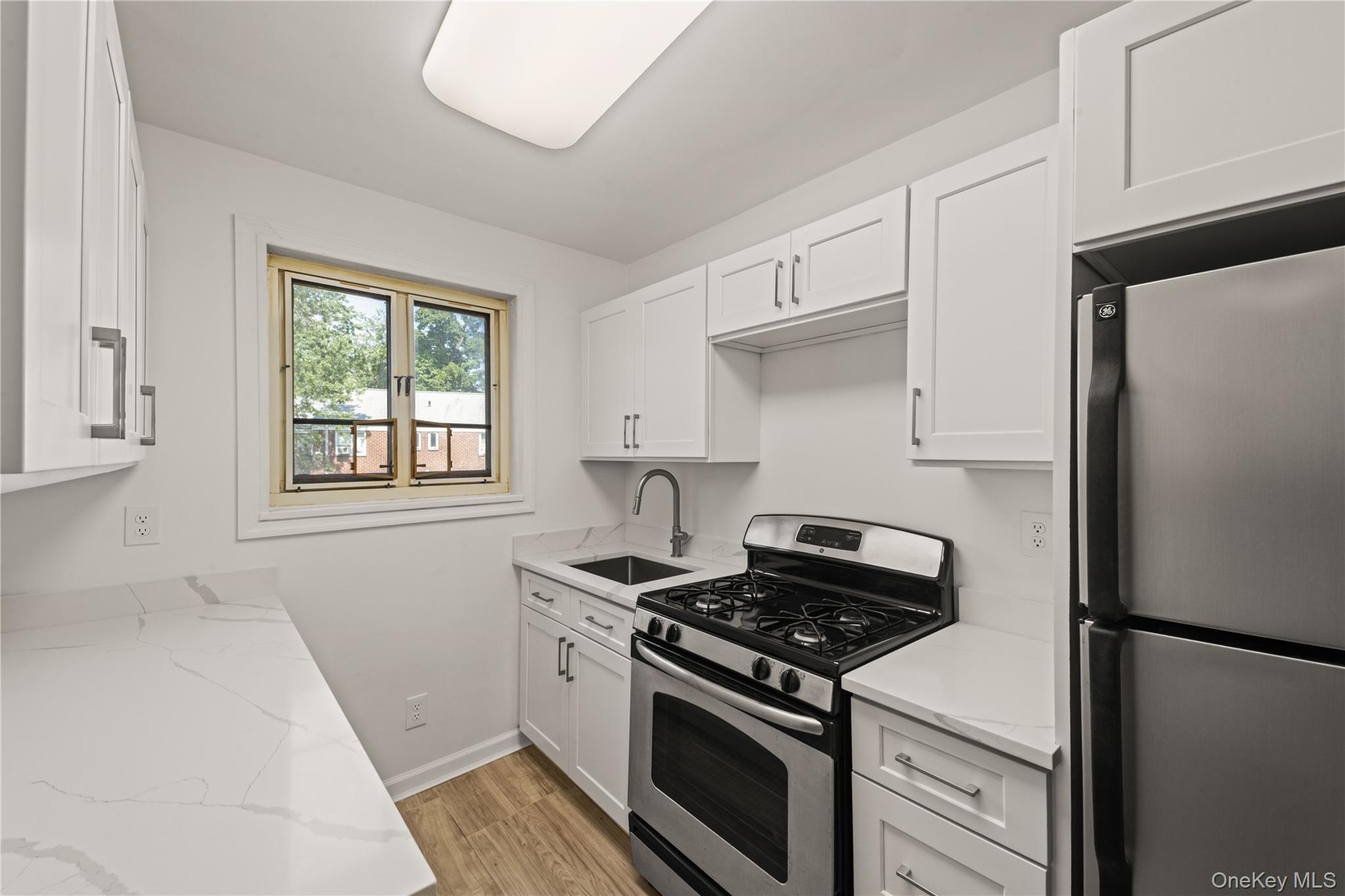 224-17 Manor Road, Unit LOWR Queens, NY 11427 - Photo 12 of 16 a kitchen with a stove and a refrigerator