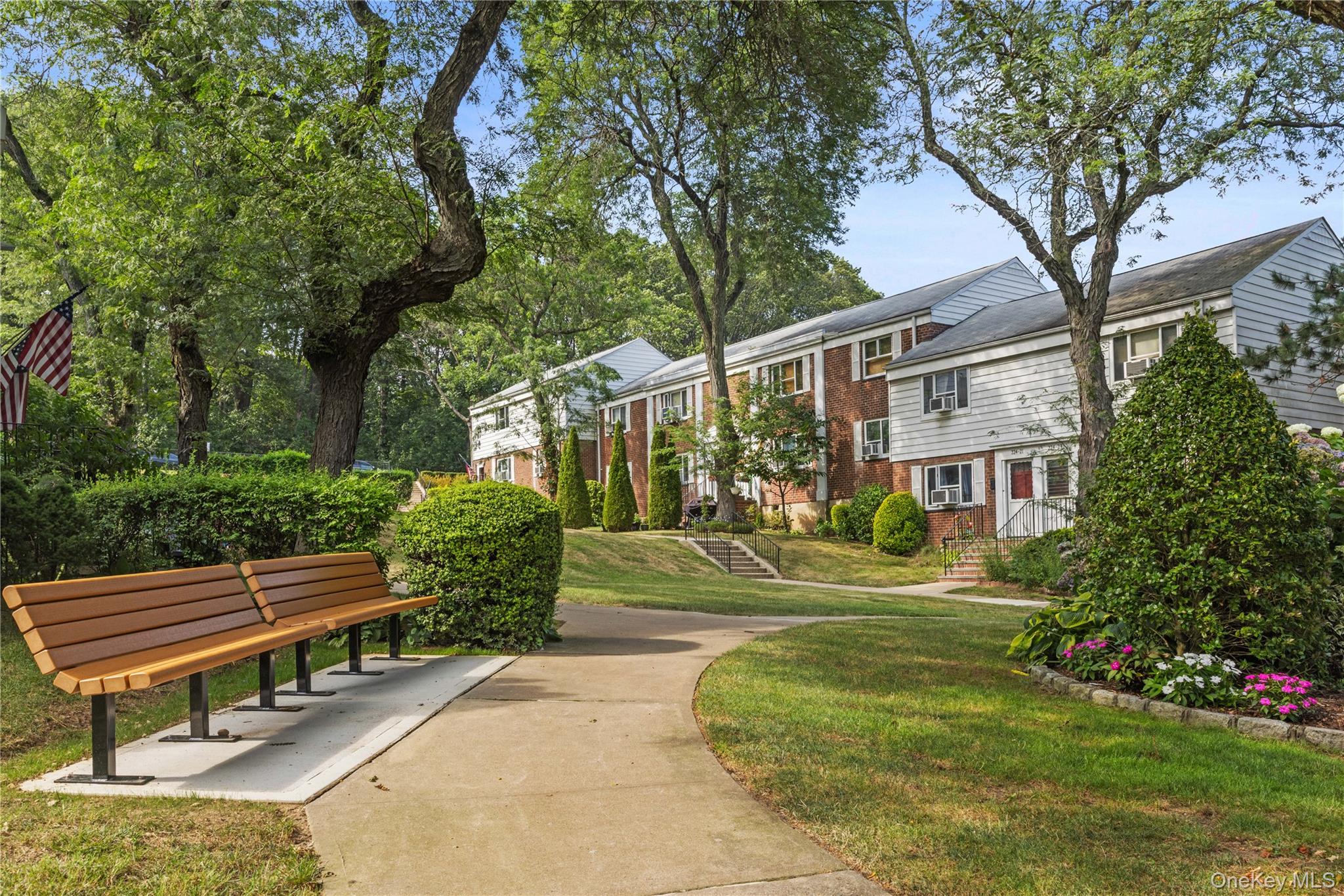 224-17 Manor Road, Unit LOWR Queens, NY 11427 - Photo 16 of 16 a front view of a house with a yard table and chairs