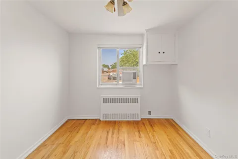 a view of a room with wooden floor and a window
