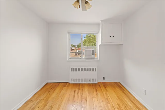 a view of a room with wooden floor and a window